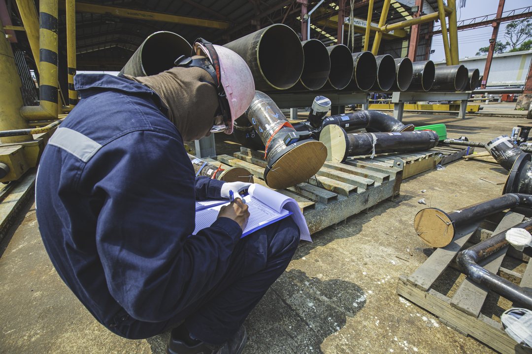 Homem trabalhando em construção fazendo a checagem da ficha técnica